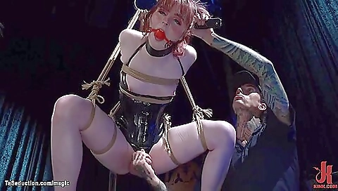 Redheaded lady in fetish bondage is getting fucked